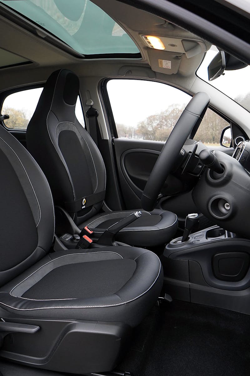 Explore a modern car's interior featuring black leather seats and advanced technology.